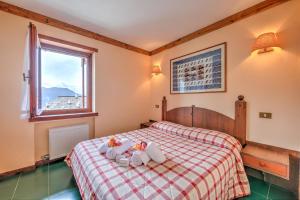 a bedroom with a bed with two stuffed animals on it at Grange Hike & Ski Sestriere Apartments - Happy.Rentals in Sestriere