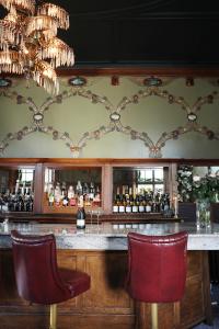 un bar con due sedie rosse davanti a un bancone di Elmbank Hotel - Part of The Cairn Collection a York