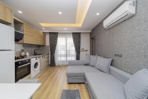 a living room with a couch and a kitchen at Chic Flat with Central Location in Muratpasa in Antalya