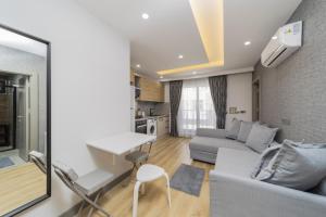 a living room with a couch and a table at Chic Flat with Central Location in Muratpasa in Antalya