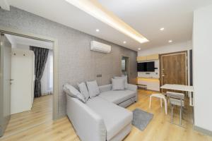 a living room with a white couch and a table at Chic Flat with Central Location in Muratpasa in Antalya