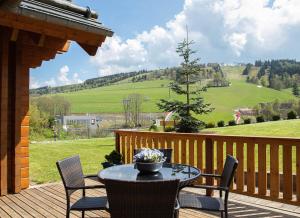a patio with a table and chairs on a wooden deck at Vakantiehuis Luxe BlokhuisA in Willingen