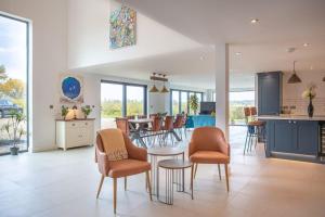 una cucina e un soggiorno con tavolo e sedie di Orchard Barn - Luxury 4 BD Barn Conversion! a Fladbury