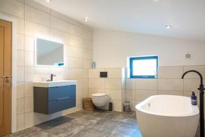 bagno con vasca, lavandino e servizi igienici di Orchard Barn - Luxury 4 BD Barn Conversion! a Fladbury