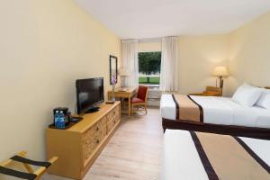 a hotel room with two beds and a flat screen tv at Quality Hotel Real Aeropuerto San Salvador in San Luis