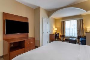 a hotel room with a bed and a flat screen tv at Comfort Suites near Texas Medical Center - NRG Stadium in Houston