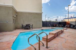 una gran piscina con mesa y sillas en Comfort Suites near Texas Medical Center - NRG Stadium en Houston