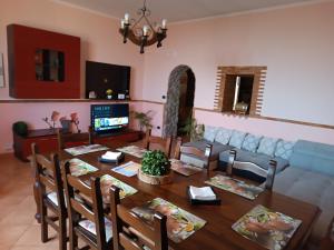 ein Esszimmer mit einem Tisch und einem Sofa in der Unterkunft Casa Vacanze Noemi in Riposto