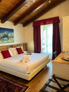 1 dormitorio con 1 cama grande y cortinas rojas en Le Charaban, en Aosta