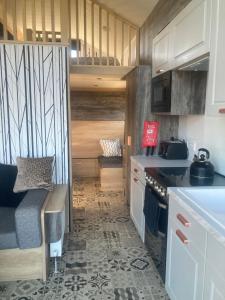 a small kitchen with white cabinets and a stove at Chapel Fields Holiday Park in Chapel Saint Leonards