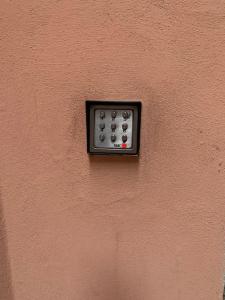 una pared con mando a distancia en una pared rosa en Loft moderno ubicato nel centro storico di Lucca, en Lucca