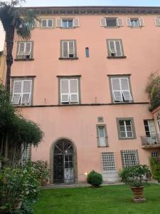 un gran edificio rosa con una puerta en un patio en Loft moderno ubicato nel centro storico di Lucca, en Lucca
