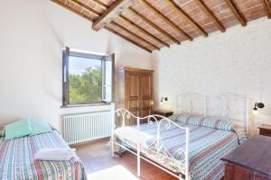1 dormitorio con 2 camas y ventana en La Collina dei Ciliegi, en Brufa