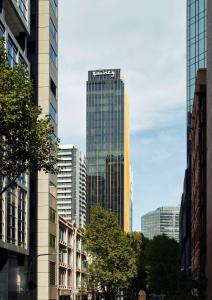 un edificio alto en medio de una ciudad en Quincy Hotel Melbourne en Melbourne