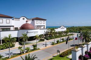 a view of the exterior of a resort with palm trees at Grand Residences Riviera Cancun, All Inclusive in Puerto Morelos