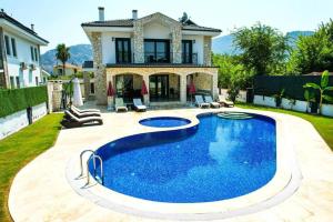 a swimming pool in the yard of a house at Stunning 4 bedrooms Luxury Villa Kaan Dalyan in Dalyan