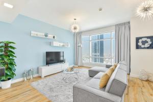 uma sala de estar com um sofá e uma televisão em Lofts · Downtown Luxury · 5 Min Walk To Dubai Fountain! no Dubai