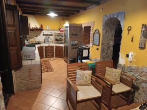 cocina con 2 sillas y cocina con fogones en Casa Vacanze Noemi, en Riposto