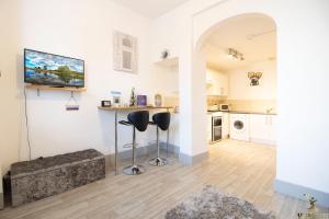 a living room with a counter and two stools at Beautiful Central Exeter Apartment 5 min walk quay in Exeter