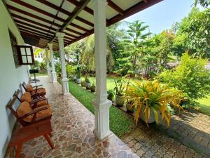 a porch of a house with chairs and plants at Dreams Villa in Hikkaduwa