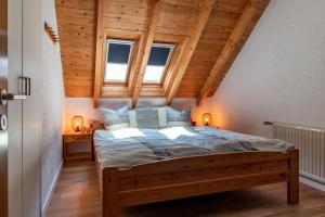 - une chambre avec un grand lit et des plafonds en bois dans l'établissement Bergzicht, à Schwalefeld