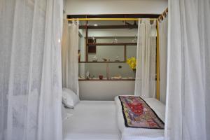 a room with white curtains and a bed with a couch at Shanti Villas - Luxury Home Stay Apartment in Jaipur