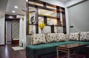 a living room with a green couch and a table at Shanti Villas - Luxury Home Stay Apartment in Jaipur