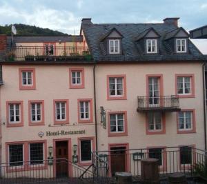 a large pink building with a hotel restaurant at Hotel Haus Irsfeld in Waxweiler