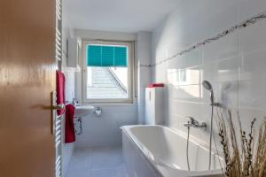 a bathroom with a tub and a sink and a window at Bödefeld in Schmallenberg +71 photos