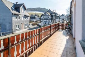 a balcony with a wooden fence and a view of a town at Bödefeld in Schmallenberg