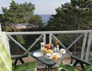 a breakfast table on a balcony with a view of the ocean at Meerblick Heringsdorf in Heringsdorf