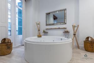 a white bathroom with a tub and a mirror at Living4Malaga Skyline Apartments in M&aacute;laga