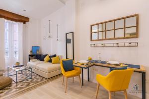 a living room with a couch and a table and chairs at Living4Malaga Skyline Apartments in M&aacute;laga