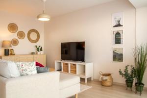 a living room with a white couch and a flat screen tv at Flat with Sea View near Karsiyaka Coast in Izmir