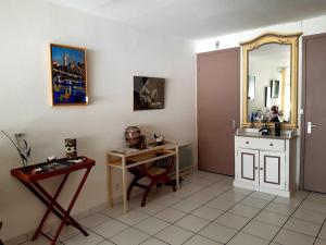 una camera con scrivania, lavandino e specchio di Bandolpiedanleau a Bandol