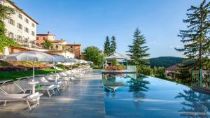 uma piscina num hotel com cadeiras e guarda-sóis em VILLA CAPPELLETTI 12, Emma Villas em Cese