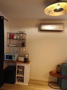 une chambre avec une table, un four micro-ondes et une lampe dans l'établissement Le Nid Bourguignon, à Chalon-sur-Saône