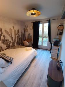 a bedroom with a bed and a table and a window at Le Nid Bourguignon in Chalon-sur-Saône