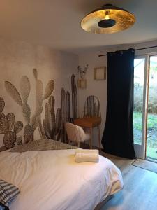 a bedroom with a cactus mural on the wall at Le Nid Bourguignon in Chalon-sur-Saône