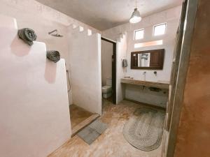 a bathroom with a sink and a toilet and a mirror at Lamu penthouse Apartment in Lamu