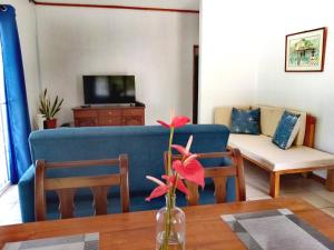 un soggiorno con divano blu e tavolo di Roz A Mer - Beach Apartment a Mahe