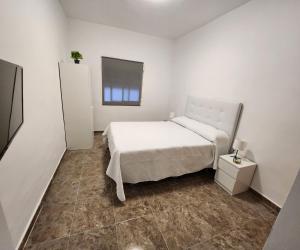 a white bedroom with a bed and a window at Apartamento Love Jacuzzi in Cartagena