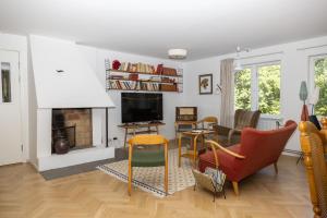 a living room with a fireplace and a tv at Mormors Pensionat Strandhagen in Stora Rör