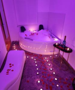 卡塔赫納的住宿－Apartamento Love Jacuzzi，紫色浴室设有浴缸,提供一瓶香槟