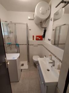uma casa de banho com um chuveiro, um lavatório e um WC. em Monolocale a 150m da impianto di risalita Spinale CIPAT O22247-AT-O11471 em Madonna di Campiglio