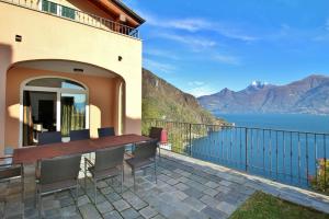 a balcony with a table and chairs and a view of the water at Villa Panoramica in Menaggio