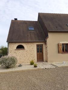 a small brick house with a brown roof at chambre chez habitant avec petit déjeuner in Bouloire