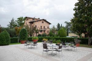 un patio con mesas y sillas frente a un edificio en Hotel Pennile en Ascoli Piceno