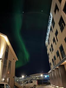 une image de l'aurore dans le ciel derrière un hôtel dans l'établissement Arctic Sea Hotel, à Hammerfest