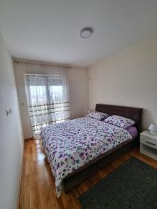 um quarto com uma cama grande com almofadas em Riverside Apartment em Podgorica